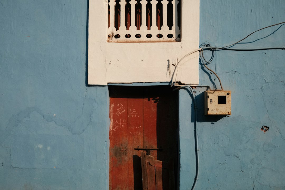 Requisitos Técnicos del Boletín Eléctrico (CIE) para tu Instalación Solar: Blue wall with red door and white window
