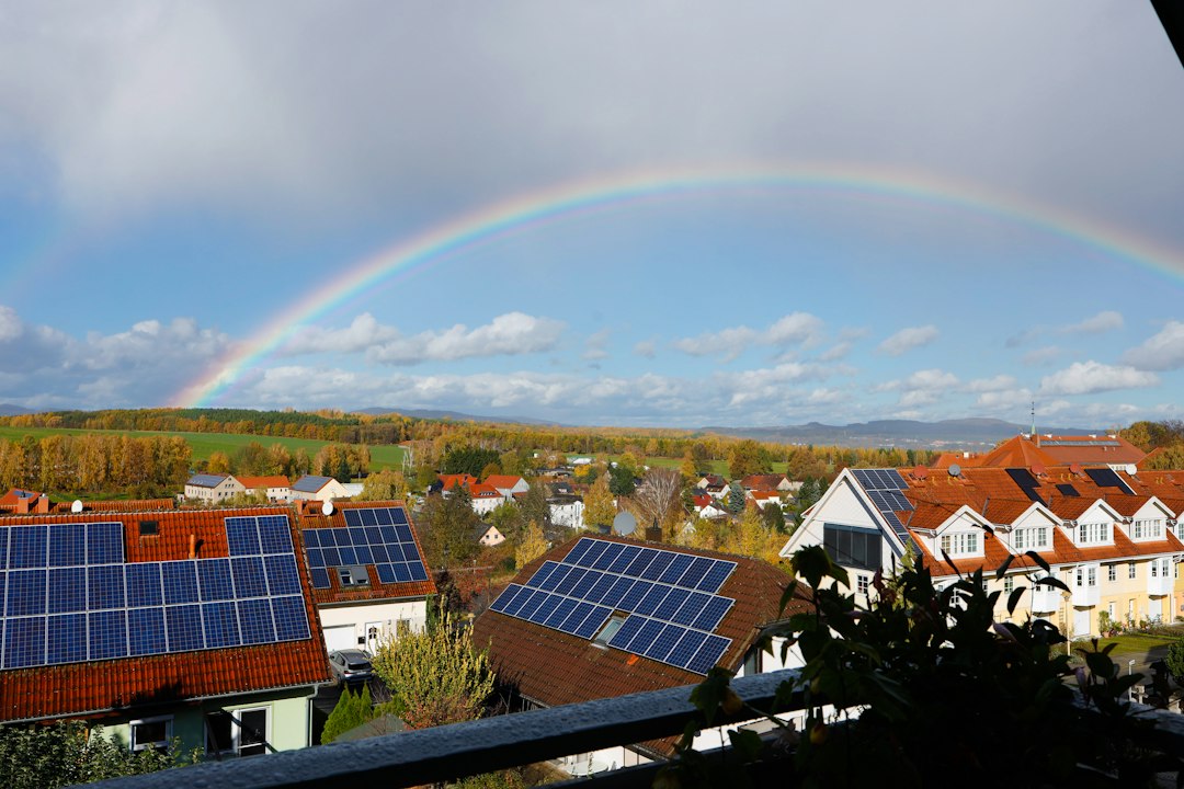 Inversores Híbridos para Placas Solares: Funcionamiento, Tipos y Selección: Rainbow over a suburban neighborhood with solar panels