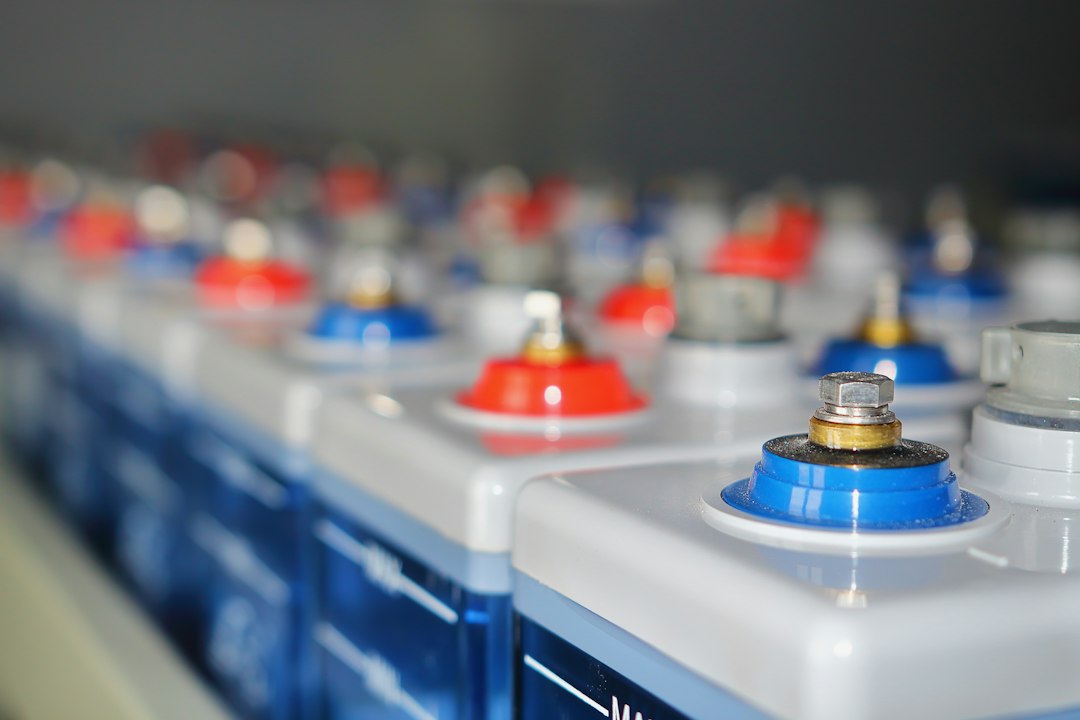 Baterías de Alto Voltaje vs Bajo Voltaje (48V): Diferencias y Eficiencia: Rows of batteries with red and blue terminals