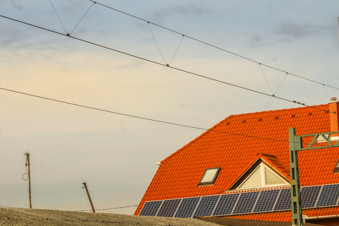 Deducción en el IRPF por Obras de Eficiencia Energética e Instalación Solar: Orange roof with solar panels and overhead wires