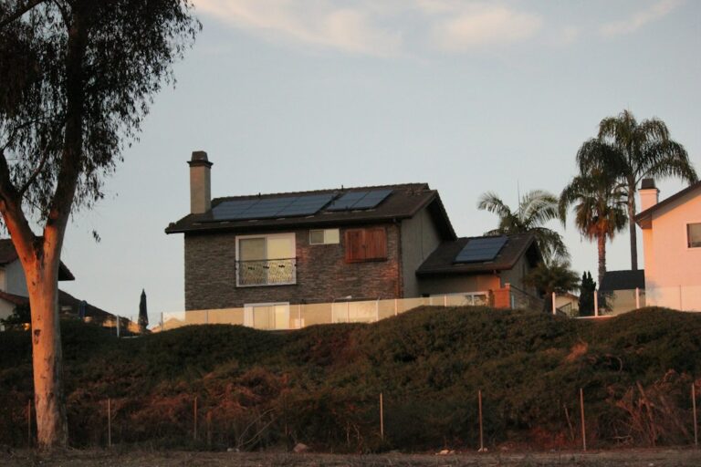 Microinversores vs Inversor Central con Optimizadores: Comparativa Exhaustiva: A couple of houses sitting on top of a hill