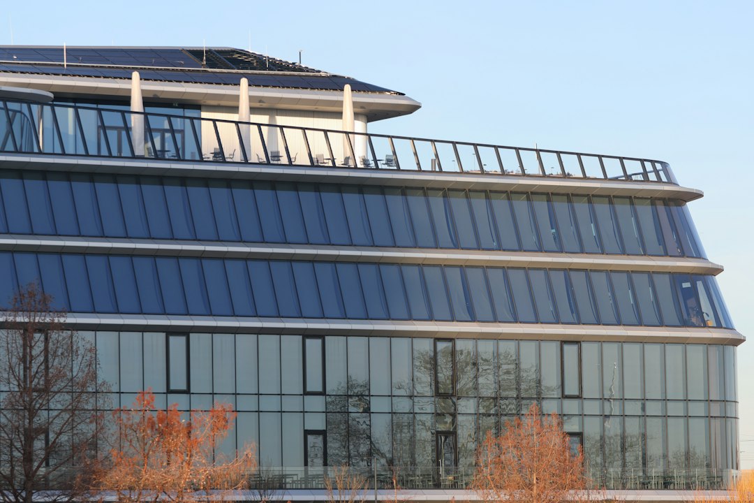 Paneles Solares Bifaciales: Cuándo Merecen la Pena en Cubiertas y Suelos: A large building with a lot of windows on top of it