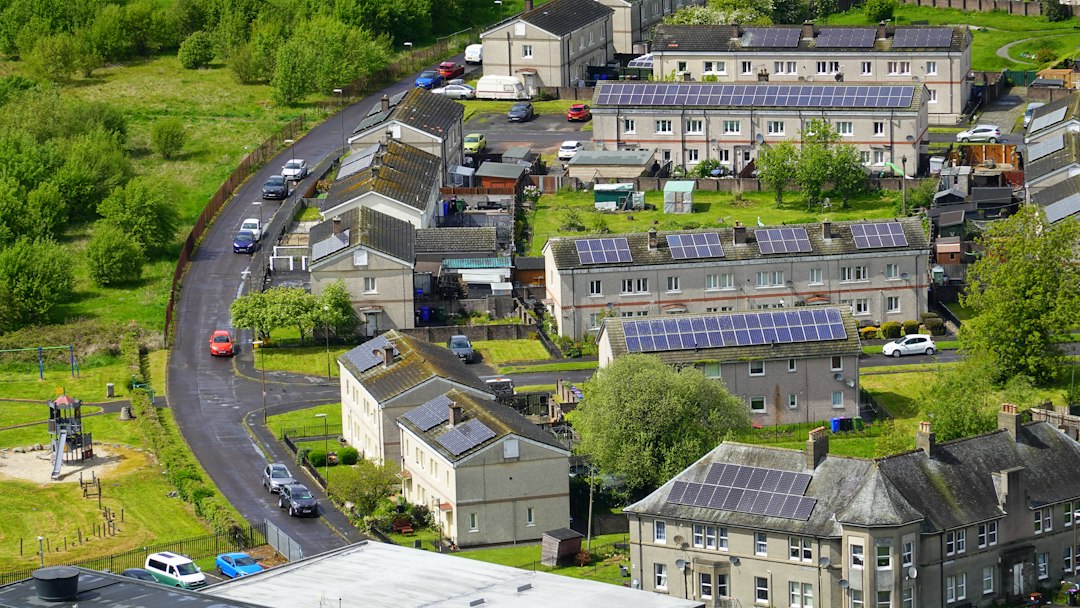 Estructuras de Fijación para Placas Solares: Tejado de Teja, Chapa y Plana: Aerial view of a residential neighborhood with solar panels on grey rooftops